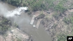 烏克蘭武裝部隊2022年5月12日提供的照片顯示烏東北頓涅茨克河上一座被烏軍摧毀的俄軍浮橋,河兩岸是被擊毀或損壞的俄羅斯裝甲車輛。