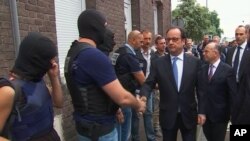 Le président français François Hollande donne une poignée de main à des policiers après la prise d'otages dans une église dans un village près de Rouen, France, le 26 juillet 2016.
