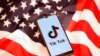 FILE PHOTO: TikTok logo is displayed on the smartphone while standing on the U.S. flag in this illustration