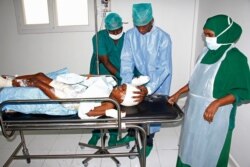 FILE - Medical workers help a child, who was injured in a mortar shell attack, at Medina hospital during Somali Independence day ceremony in Mogadishu, Somalia, July, 1, 2018.