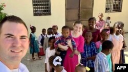 Nesta imagem, os missionários norte-americanos Davy e Natalie Lloyd, que foram mortos no Haiti em 23 de maio de 2024, posando com crianças haitianas