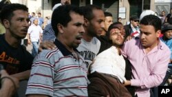 Des manifestants portent un blessé après des affrontements contre la police, à Casablanca, Maroc, 20 février 2011.