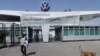 FILE - An employee leaves the Volkswagen plant as the company temporarily closes its factories in Mexico amid growing worries over the spread of the coronavirus disease, in Puebla, Mexico, March 29, 2020.