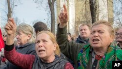 Supporters of the government shout slogans outside Moldova's parliament during a rally in Chisinau, Moldova, Nov. 12, 2019. 