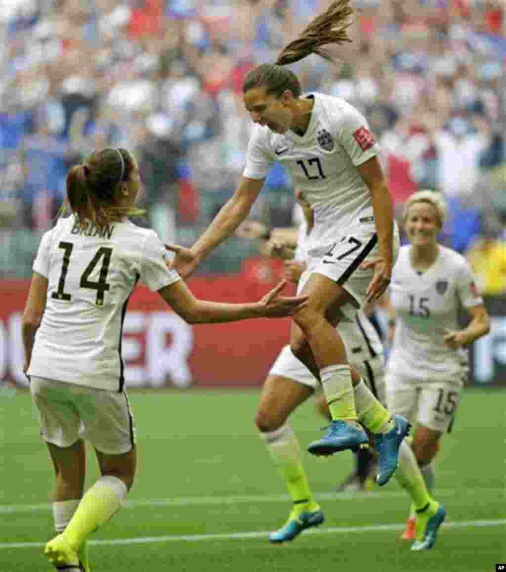 United States' Tobin Heath, center, celebrates with Morgan Brian, left, after Heath scored a goal against Japan during the second half of the FIFA Women's World Cup soccer championship in Vancouver, British Columbia, Canada, July 5, 2015.