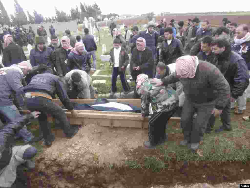 Relatives and Free Syrian Army fighters bury the body of Ammar Al-Achaqer, who activists said was killed by forces loyal to Syria&#39;s President Bashar al-Assad, near Homs, Syria, January 29, 2013. (Shaam News Network)