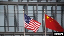 美中国旗在一家美国公司驻北京的办公楼外飘扬（路透社2021年1月21日）