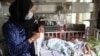 FILE - Babies lie in their beds at the Ataturk Children's Hospital a day after they were rescued following a deadly attack on another maternity hospital, in Kabul, Afghanistan, May 13, 2020. 