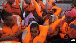 Des migrants secourus transportés un bateau en mer Méditerranée au large des côtes libyennes, le 4 octobre 2016