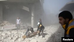 Des membres de la défense civile syrienne et des civils transportent un blessé dans la ville de Hamoria, Ghouta orientale, près de Damas, en Syrie, le 3 décembre 2017.