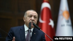 FILE - Turkish President Recep Tayyip Erdogan addresses lawmakers from his ruling AK Party during a meeting at the parliament in Ankara, Turkey, Nov. 26, 2019. 