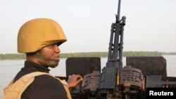 ARCHIVES - Un officier de la marine nigériane sur un bateau au large de la côte atlantique dans l'État de Bayelsa au Nigeria, le 19 décembre 2013.