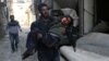 A man carries an injured boy in the rebel-held besieged town of Hamouriyeh, eastern Ghouta, near Damascus, Syria, Feb. 21, 2018.