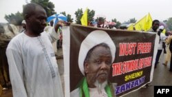 Des partisans du mouvement islamique pro-iranien au Nigeria (IMN) tiennent une banderole avec une photo du leader détenu Ibrahim Zakzaky dans la ville de Kano, au nord du Nigeria, le 11 août 2016.