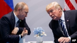 Le président américain Donald Trump, à droite, et son homologue russe Vladimir Poutine lors du sommet du G20 à Hambourg, Allemagne, 7 juillet 2017. 